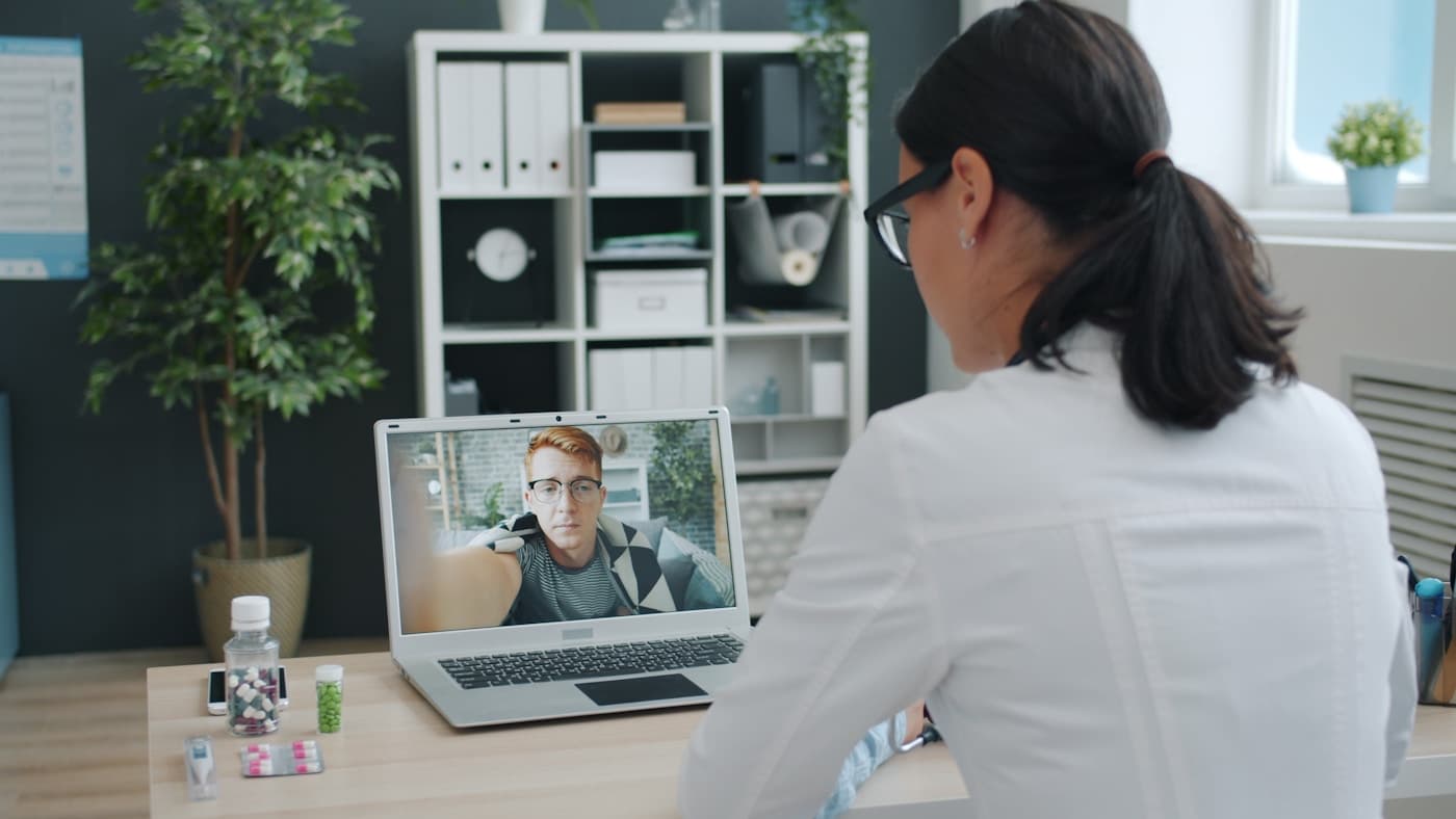 Doctora realizando una consulta online desde un portátil, imagen realista para campañas sanitarias