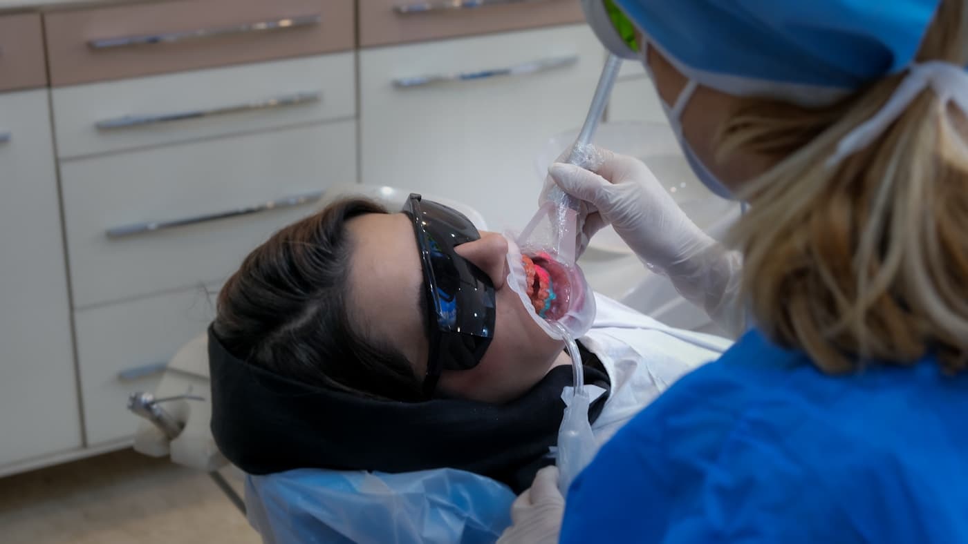 Dentista atendiendo a un paciente en una clínica dental, imagen realista para SEO local dental en Sevilla